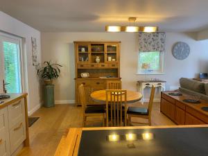 a kitchen and living room with a table and a couch at Thistle Haugh the peaceful house with a hot tub in Barcaldine