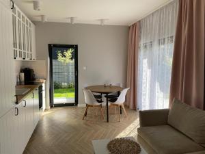 a living room with a table and a couch and a kitchen at Apartament Ustrońska Jodełka z Sauną-Nadrzeczna in Ustroń
