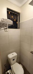 bagno con servizi igienici bianchi e finestra di Cosy Living a Gulu