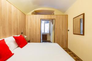 een slaapkamer met een wit bed met rode kussens bij Amphitheater Apartment by Wonderful Italy in Napels