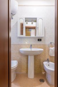 een badkamer met een wastafel, een toilet en een spiegel bij Amphitheater Apartment by Wonderful Italy in Napels