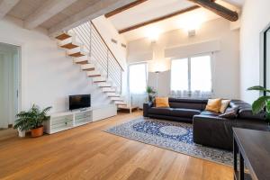 a living room with a couch and a tv and stairs at Clock's 2 bedrms 2 baths big terrace loc13324 in Venice-Lido