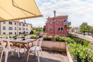 a wooden table and chairs on a balcony with a building at Clock's 2 bedrms 2 baths big terrace loc13324 in Venice-Lido
