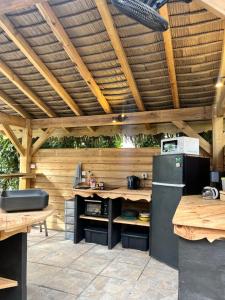 an outdoor kitchen with a wooden pergola at Caraiba Villa & Bungalows in Sainte-Anne