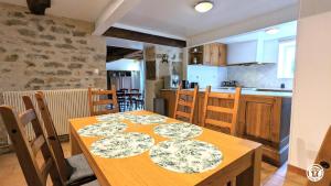 uma sala de jantar com uma mesa e uma cozinha em Le Gîte des Roses em Essey