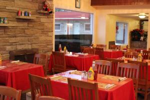 um restaurante com mesas e cadeiras vermelhas e uma parede de tijolos em Imperial Inn 1000 Islands em Gananoque