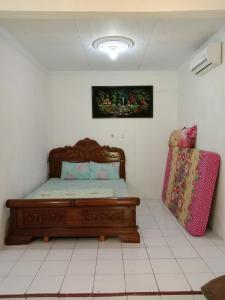 a bedroom with a bed and a pink suitcase at Rumah Ukhi in Yogyakarta