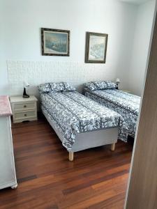 a bedroom with two beds and a night stand at Finestre Verdi appartamento con parcheggio in Ronchi dei Legionari