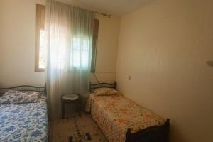 a small bedroom with two beds and a window at Apparemment meublé à Kénitra in Kenitra