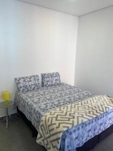 um quarto com uma cama e uma mesa amarela em Residencial Maurice et Madeleine em São Paulo