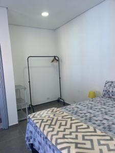 um quarto com uma cama e um quadro branco na parede em Residencial Maurice et Madeleine em São Paulo