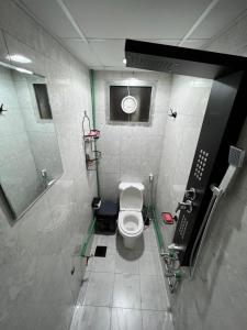 y baño con aseo, lavabo y espejo. en Dinar apartments - twin bed, en Abu Dabi