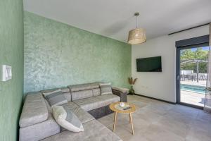 a living room with a couch and a tv at Villa Ivana with Private Pool in Nova Vas