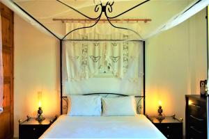 a bedroom with a canopy bed with two lamps at Eva Seaside 1st Floor in Koutsounari +132 photos