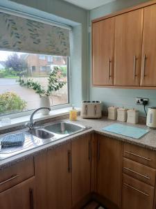 eine Küche mit einem Waschbecken und einem Fenster in der Unterkunft Stunning Views Peaceful Split Level Bungalow in Sutton in Ashfield