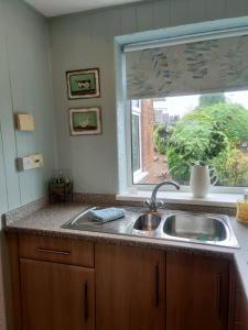 a kitchen counter with a sink and a window at Stunning Views Peaceful Split Level Bungalow in Sutton in Ashfield