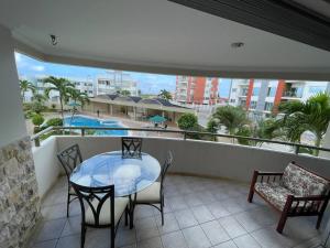 a balcony with a table and chairs and a pool at Condominio vizcaya in Salinas