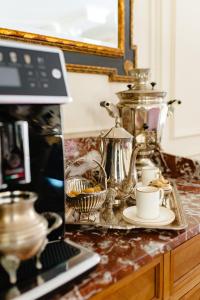 a counter top with a laptop and a cup and aucer at Ateneea Luxury Rooms in Cluj-Napoca