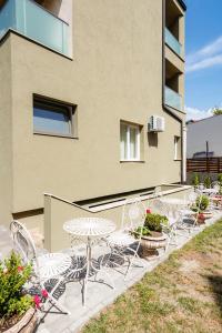 a row of chairs and tables on a patio at Ateneea Luxury Rooms in Cluj-Napoca