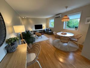 a living room with a table and chairs and a tv at Apartments Bergen with sea view! in Bergen
