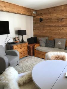 a living room with a couch and a table at Tignes : cocon luxueux au pied des pistes in Tignes