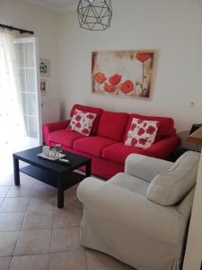 ein Wohnzimmer mit einem roten Sofa und einem Tisch in der Unterkunft Sunny stay furnished apartment in Kanoni in Kanoni