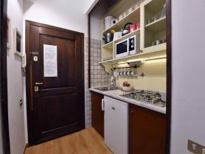 a kitchen with a stove, refrigerator, sink and cabinets at Ascanio Twenty Six in Rome
