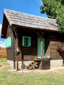 uma cabana de madeira com um alpendre e uma janela em Cottages of Nišići em Saraievo