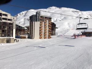 a ski resort with a ski lift in front of a mountain at Tignes : cocon luxueux au pied des pistes in Tignes
