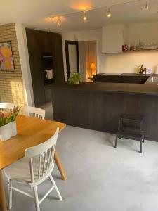 a kitchen and dining room with a wooden table and chairs at Cheerful 3-bedroom Home, Close To Lakes in Farum