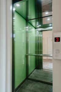an elevator with green walls and a glass door at Ateneea Luxury Rooms in Cluj-Napoca