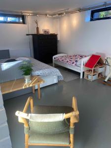 a room with two beds and a chair and a table at Cheerful 3-bedroom Home, Close To Lakes in Farum