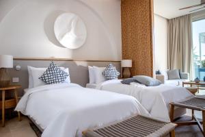 um quarto de hotel com duas camas e um espelho em Yalikavak Marina Hotel By Social Living Collection em Yalıkavak
