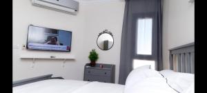 Port Said city, Damietta Port Said coastal road في بورسعيد: غرفة نوم مع تلفزيون على جدار أبيض