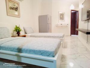 two beds in a room with white walls and tile floors at Port Said city, Damietta Port Said coastal road in Port Said