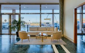 Una sala de estar con un sofá y dos sillas y una mesa. en Checkin Madrid Móstoles, en Móstoles