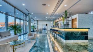 vestíbulo con bar, sillas y ventanas en Checkin Madrid Móstoles, en Móstoles