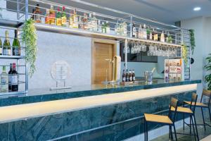 un bar con encimera de mármol azul y taburetes en Checkin Madrid Móstoles, en Móstoles