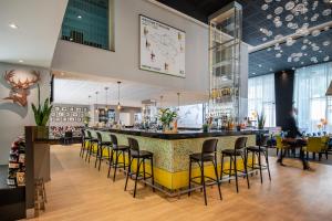a bar in a restaurant with yellow bar stools at Thon Hotel EU in Brussels