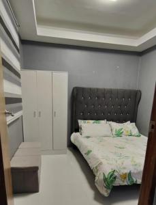 - une chambre avec un lit doté d'une tête de lit noire dans l'établissement Golden Mountain Homestay, à Rizal