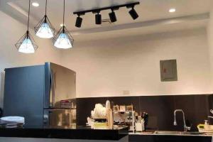 a kitchen with three lights hanging from the ceiling at Sky Haven Staycation in Rizal