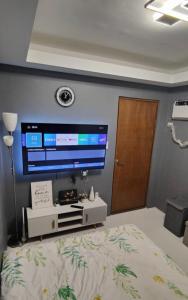 a bedroom with a large television on the wall at Golden Mountain Homestay in Rizal