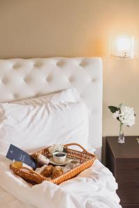 - un panier de nourriture et de pain sur le lit dans l'établissement Villa Antica Colonia - Lake Orta - Suite Apartments Adults Only - SPA & Wellness, à Pettenasco