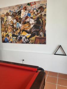 une peinture accrochée à un mur à côté d'un banc dans l'établissement Solar de Arrayollos Charming House, à Arraiolos