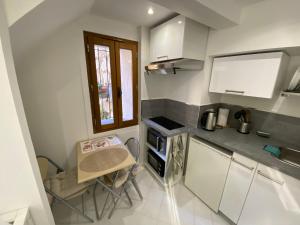 a small kitchen with a small table and a counter at O' Cœur de Menton in Menton