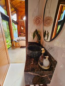 een badkamer met een bad en een spiegel bij Cabanas Bougainville Hospedagem sofisticada em nova Petrópolis in Nova Petrópolis