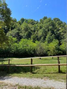 a wooden fence in front of a field with trees at Agriturismo Rio Verde in Sasso Marconi