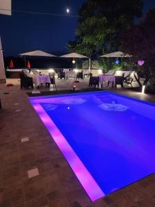 een zwembad 's nachts met paarse verlichting bij Andale SuiteSpa in Villa Badessa