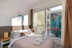 a bedroom with a large window with towels on a bed at Chic & Elegant 2BR 1.5BA Residence w Priv Terrace #6 in Istanbul