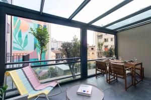 Cette chambre dispose d'une grande fenêtre et d'une table avec des chaises. dans l'établissement Chic & Elegant 2BR 1.5BA Residence w Priv Terrace #6, à Istanbul